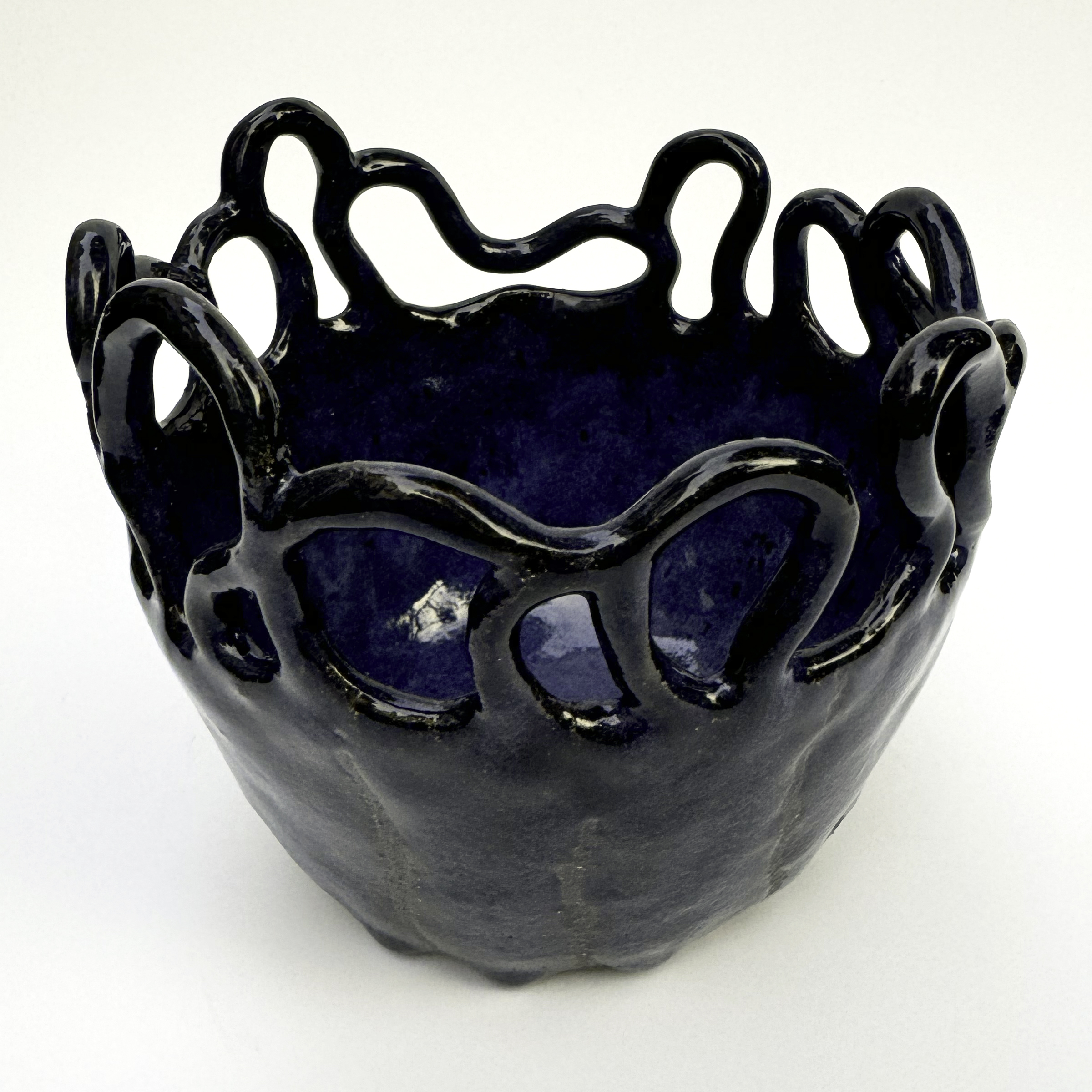 The bowl is glazed a very glossy dark blue with some hare's fur variation of lighter blues.