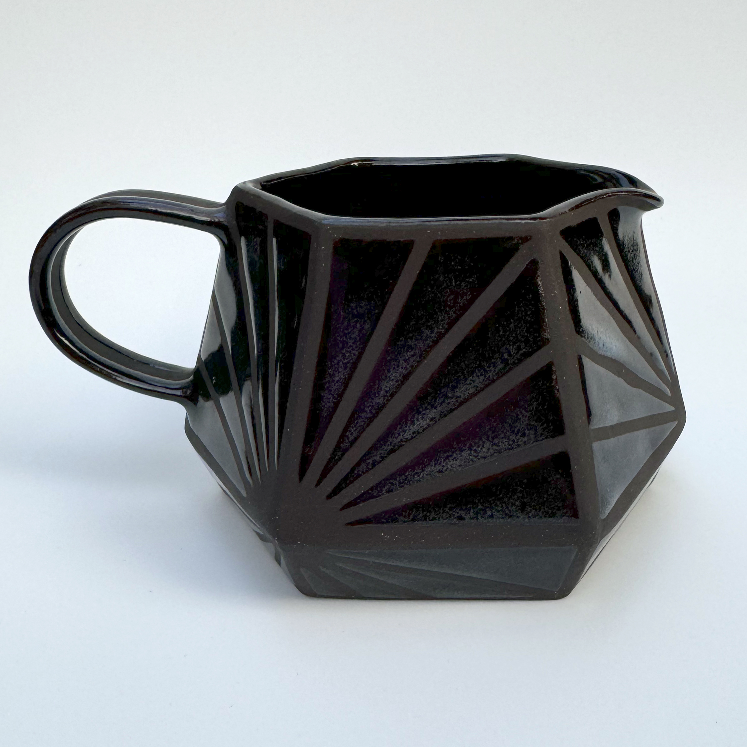 The glaze is mostly transparent but speckles of blues, both light and navy, float in each section of glaze.