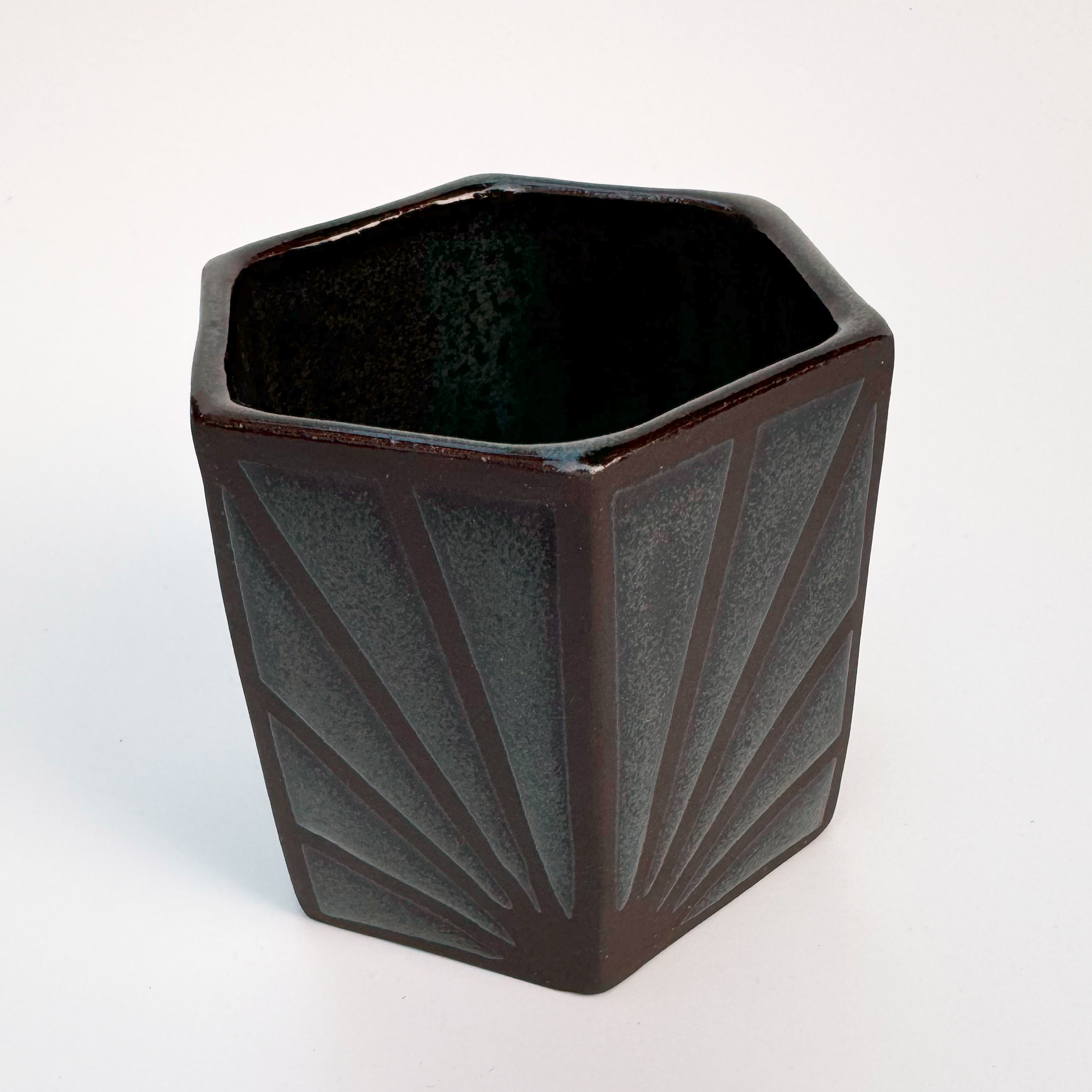 The glaze has a dark teal base, and speckles of blues, both light and navy, float in each section of glaze.