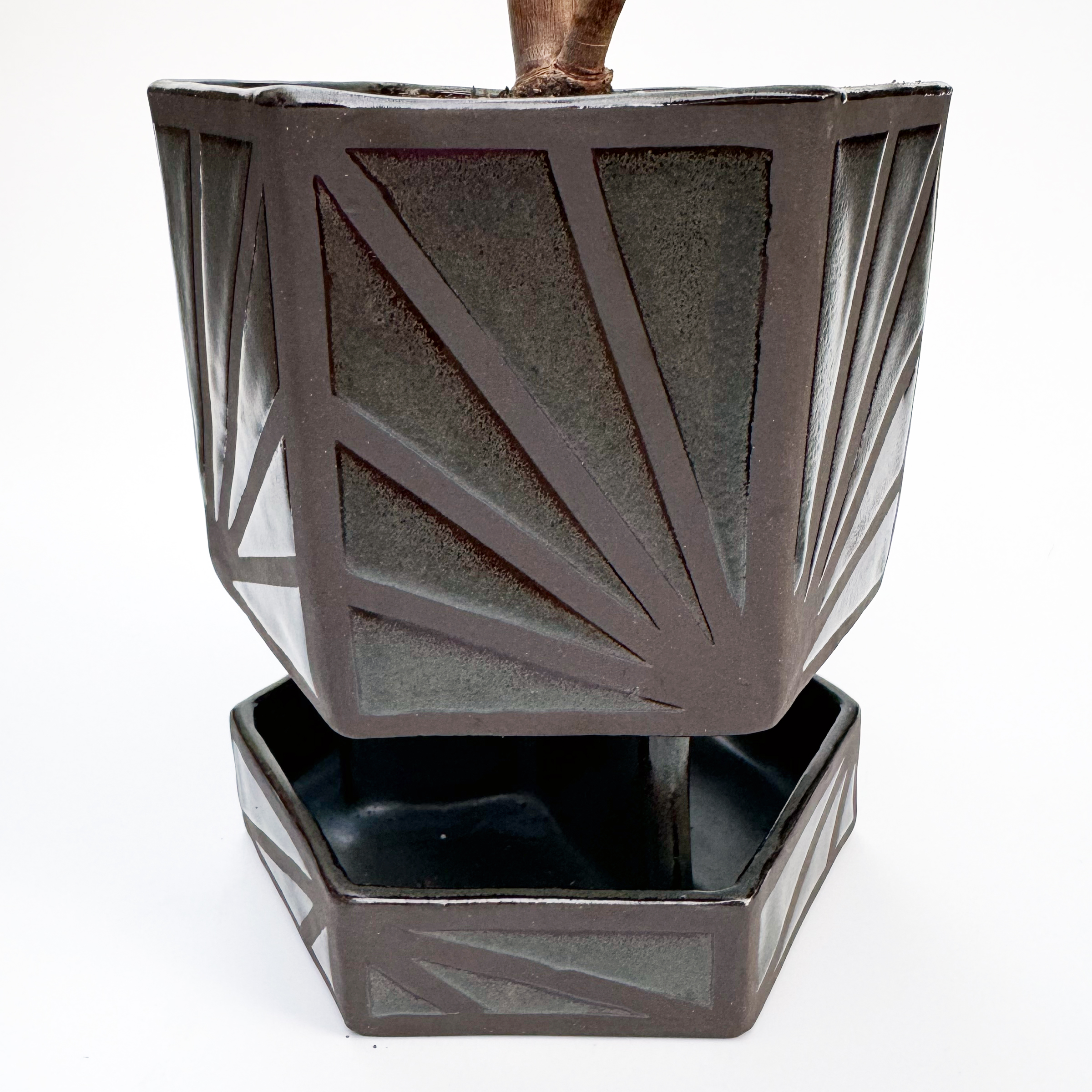 The main body sits atop three stilts that meet in the middle above a hexagonal drip tray.