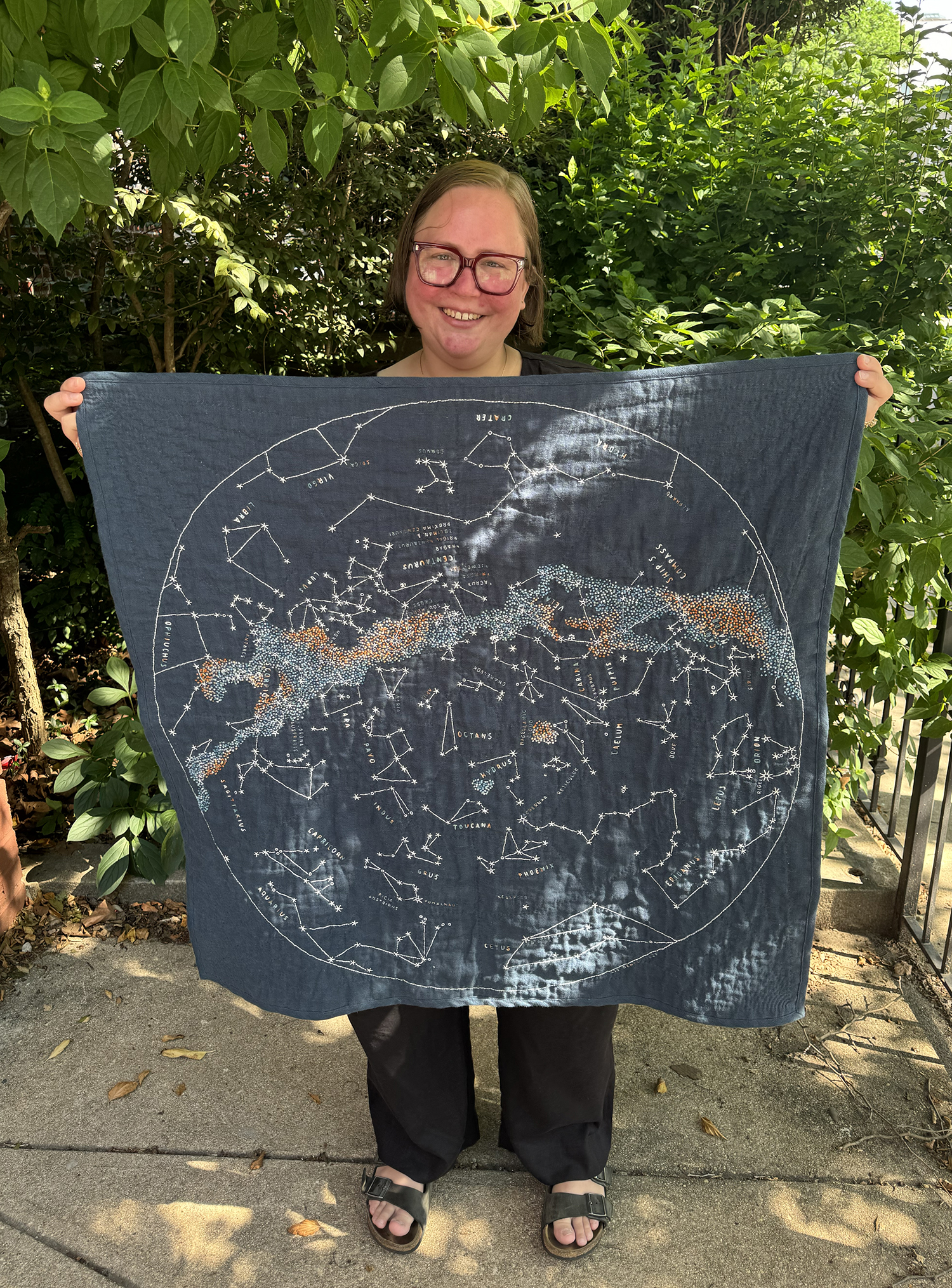 Me holding up my Southern Sky quilt. The quilt is composed in the same style and materials as the Northern Hemisphere quilt.