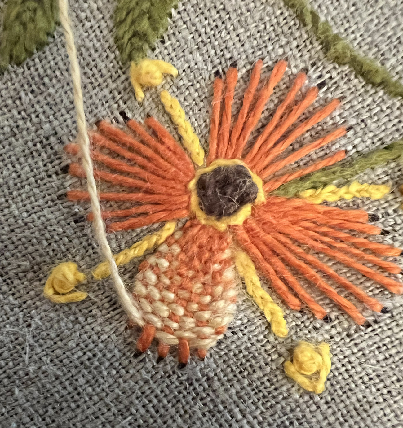 The light peachy pink is woven through the red orange warps that run from the center out to the tip of the petals. As the warp is denser near the center, that part of the petal is more coral, and the tips of the petal have a denser peachy pink since the warp lines are more spread outs.