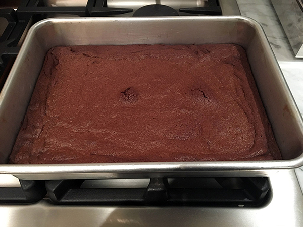 A double batch of cocoa brownies in a 13x9-inch pan sitting on a stovetop