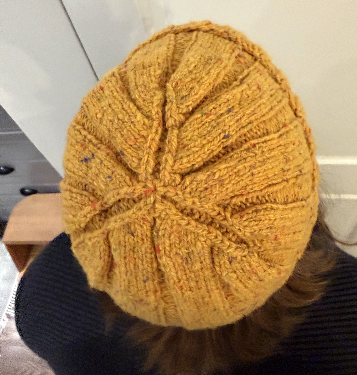 Three 2-stitch wide purl sections continue all the way to the center of the top of the hat, forming a channeled 3-pointed star.