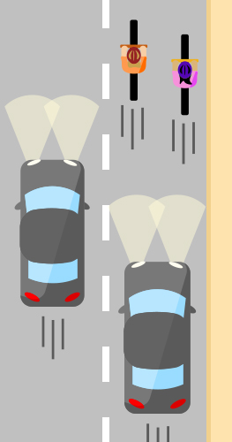 Two people bicycling side by side in the rightmost lane of traffic on a street without bike lanes