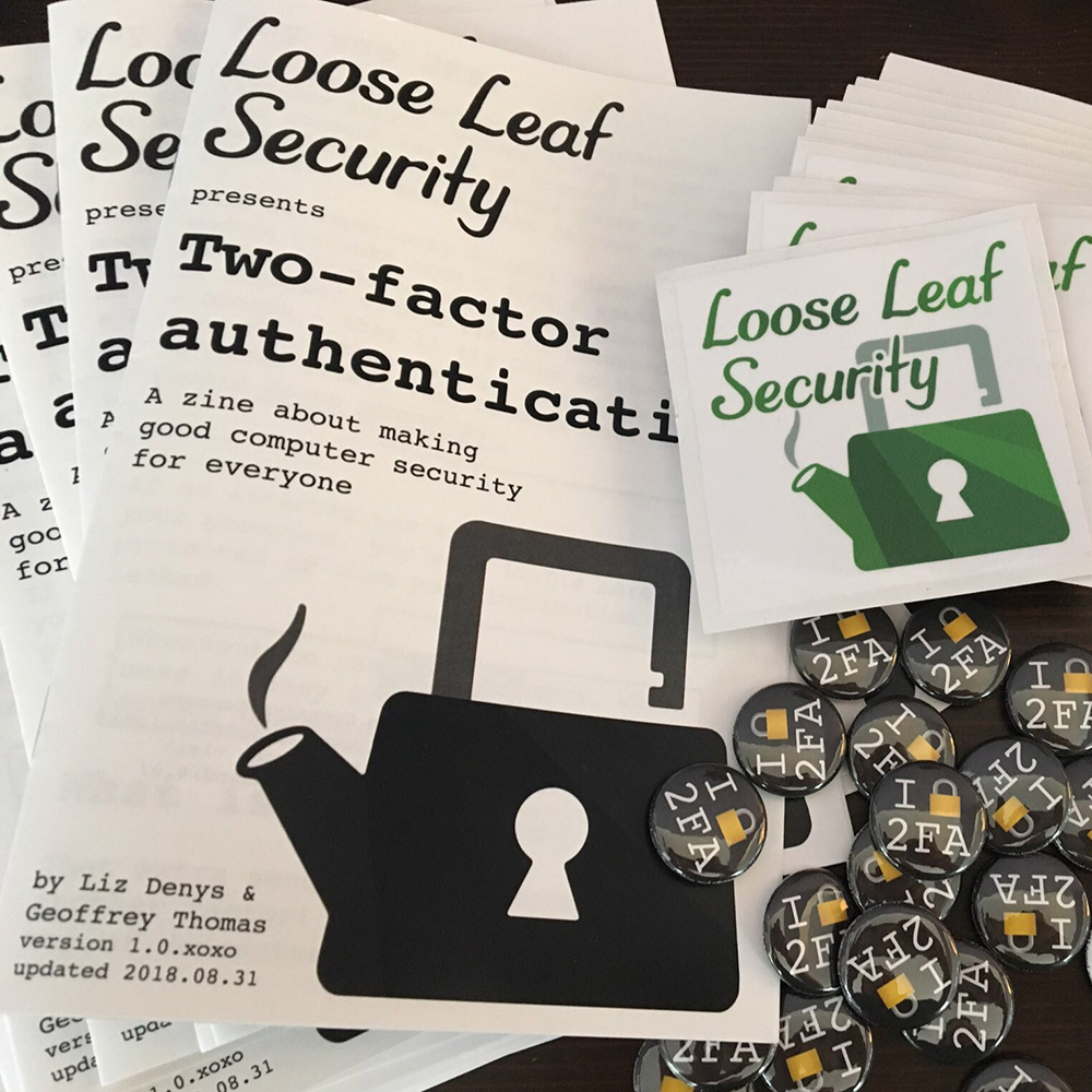 A stack of Loose Leaf Security presents Two-factor authentication zines next to Loose Leaf Security logo stickers and I lock 2FA pins